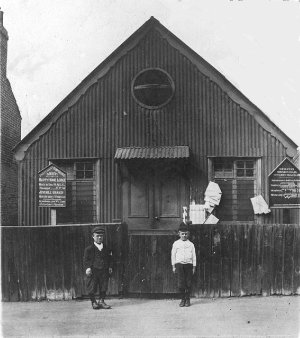 Church Hall in Sutcliffe Road just off the Slade. Alf Hall (the dwarf man) worked at Mackintoshes as maintenance engineer and because he was smaller than most was able to get into very tight places. Mackintoshes was at the bottom of Kings Highway. The boy is Fred Smith. The photo is c. 1918. Photo: John Miles